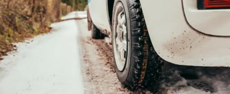 Low angle view close up classic car driving in winter snowy road