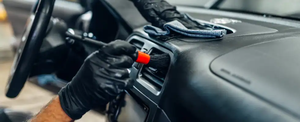 person cleaning vehicle interior