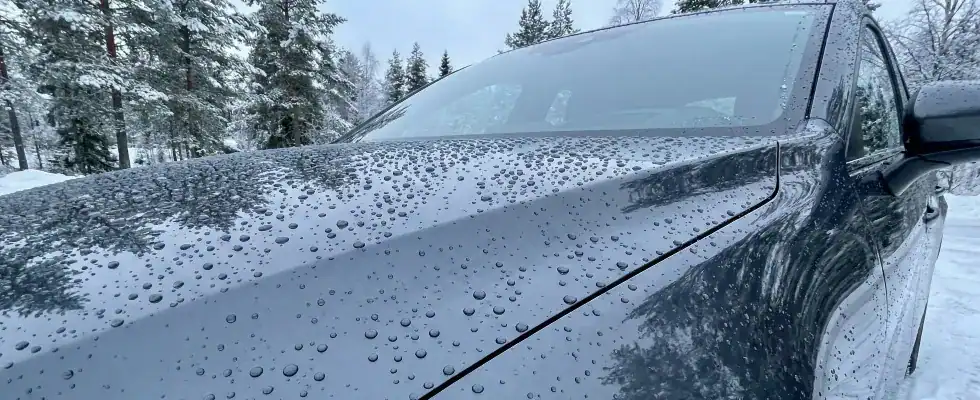 black car with rain drops on hood during winter