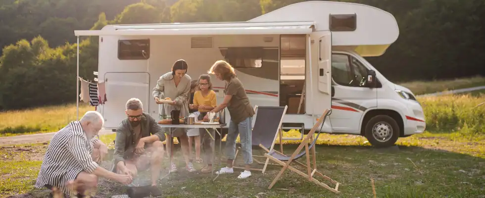 family eating at a camper parked after a trip in the middle of nature