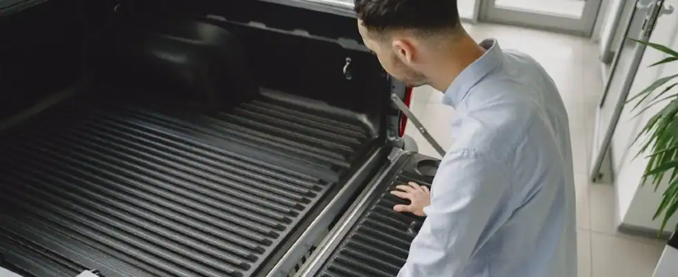 man checking truck bed liner condition
