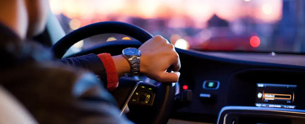 man driving a car wearing wrist watch