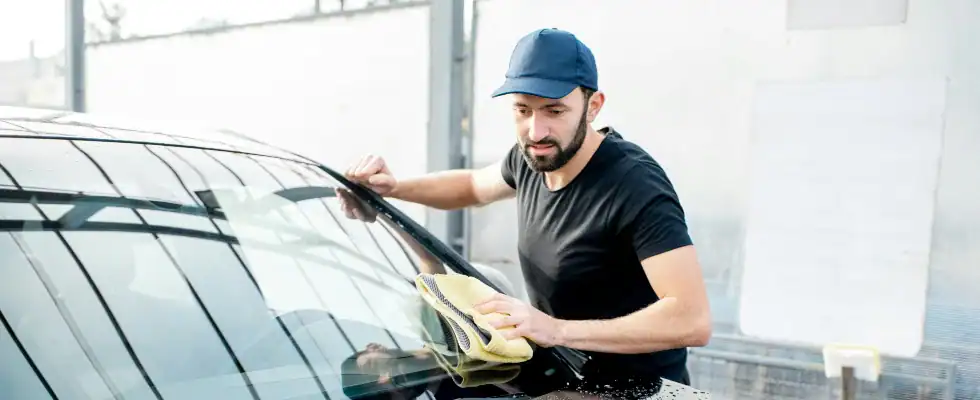 man in black crew neck t-shirt putting ceramic coating on glass